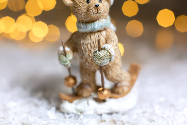 istock Decorative Christmas-themed figurines. Statuette of a teddy bear skiing. Christmas tree decoration. Festive decor, warm bokeh lights 1185292155