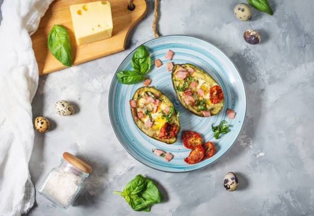 istock Keto diet: Avocado with ham, quail eggs, cheese on concrete background 1185293292