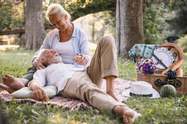istock Caring woman cuddling a man resting on her lap in nature 1185293971