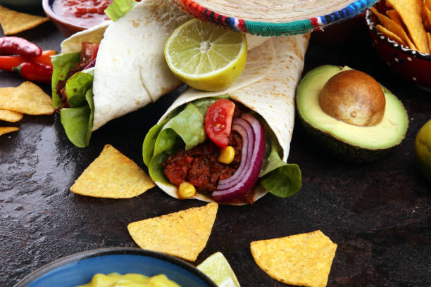 istock Mexican food, including tacos, guacamole, nachos and pepper on rustic table 1185295158