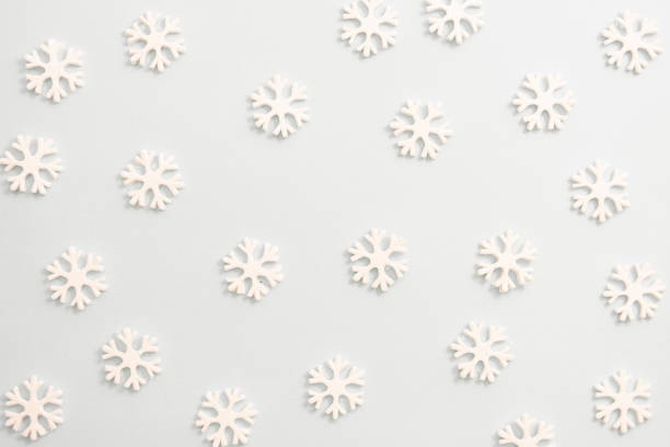 istock Winter background, white snowflakes over white board. Abstract Christmas winter texture. 1185300612