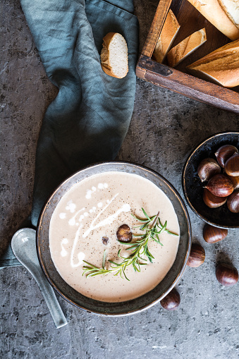 Healthy dish, creamy chestnut soup with sour cream in a ceramic bowl