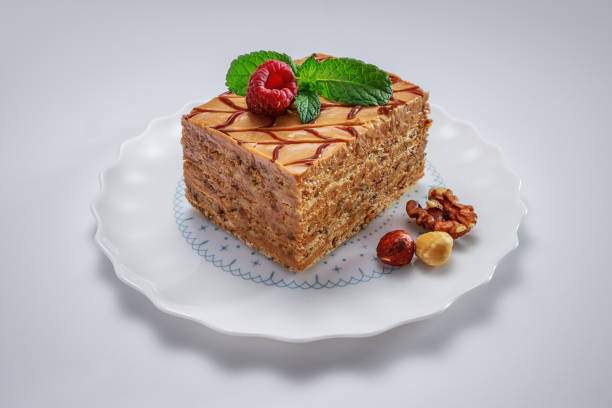 istock Cake piece with nuts, chocolate, mint and raspberry on a plate isolated on background. 1185305754