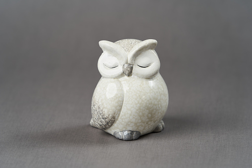 White owl toy over grey background with copy space, close-up