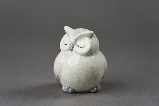 White owl toy over grey background with copy space, close-up