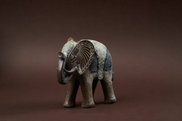 Decorative elephant toy on brown background with copy space, close-up