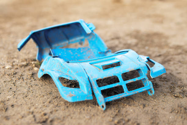 istock A broken plastic toy lies on the ground. Broken car without wheels 1185309944