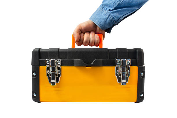 Isolated photo of a worker male hand holding yellow industrial toolbox. stock photo