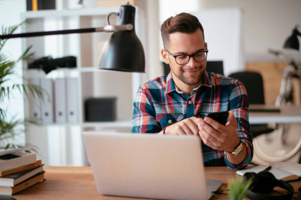 istock Young businessman in office using smartphone.stock photo 1185311282