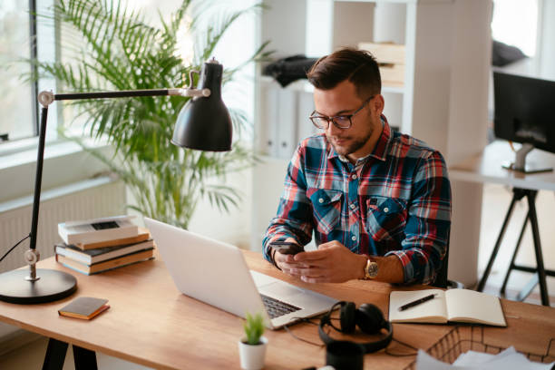 istock Young businessman in office using smartphone.stock photo 1185312094
