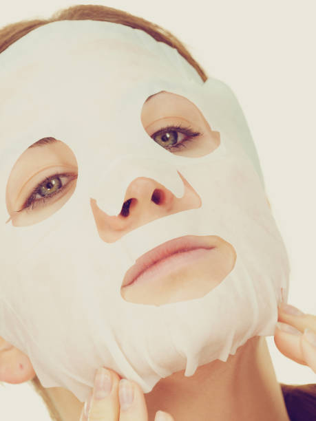 istock Woman applying sheet mask on face 1185315706