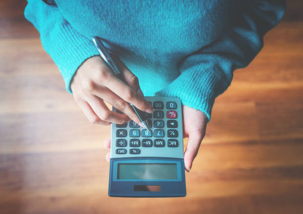 Woman using a calculator Finance, Savings, Wages, Loan, Calculator button sewing item photos stock pictures, royalty-free photos & images