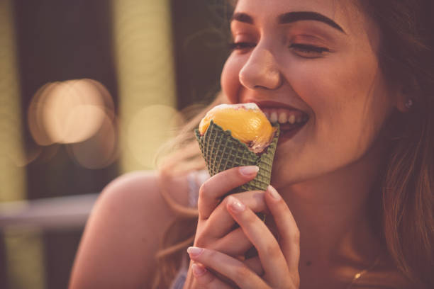 istock Smiling woman eating ice cream 1185316759
