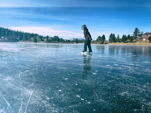 istock Child Ice Skating on a Pond 1185316872