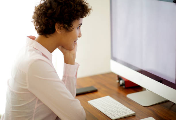 istock young woman sitting with computer and looking at screen 1185317070