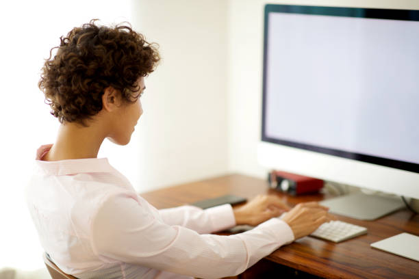 istock young business woman sitting by computer in office 1185317073