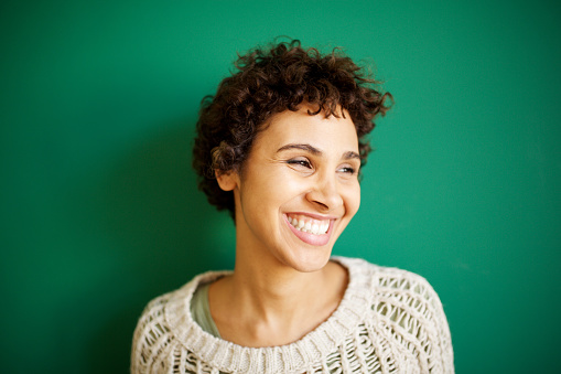 Close up portrait of happy young african american woman against green background