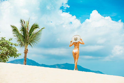 Woman in sunhat at tropical beach