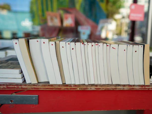 rząd używanych książek siedzących na półce przed sklepem - book book spine shelf in a row zdjęcia i obrazy z banku zdjęć