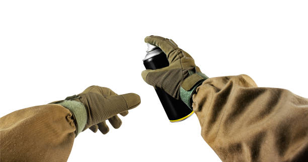 istock Hands in tactical jacket and gloves holding paint spray can. 1185321151