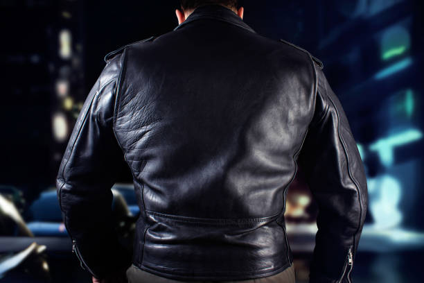 istock Black leather biker in jacket standing on night citylights background. 1185321490