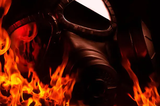 Photo of Burning military gas mask laying in flames.