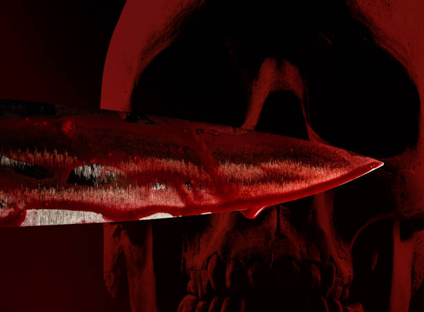 istock Bloody splattered kitchen knife blade on red skull. 1185321639