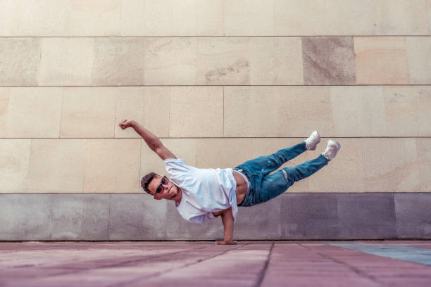istock Superman flight, male acrobat dancer, handstand, dancing breakdance, summer city, free space text, hip hop break dancer. Youth lifestyle, active, trendy, modern, fitness sport, positive motivation. 1185322705