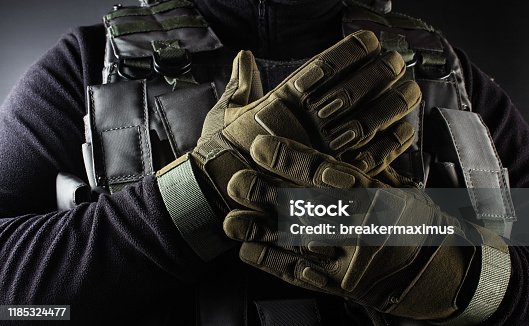 istock Soldier in black armor tactical vest and gloves standing. 1185324477