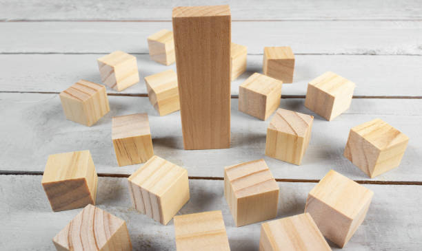 istock Small wooden blocks surrounding a bigger block. 1185325291