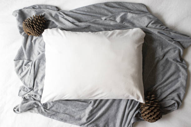 istock Plain white pillowcase on a grey and white textile background with autumn pine cones 1185325309