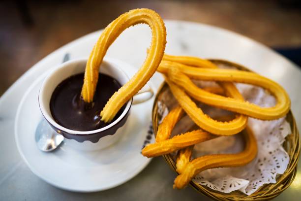 deliciosos churros y chocolate caliente en españa - churro chocolate cup sweet food fotografías e imágenes de stock