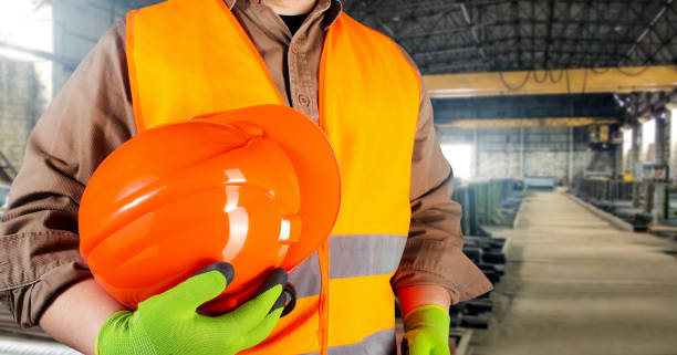 istock Worker in orange jacket outfit with gloves holding protective orangle helmet. 1185325484