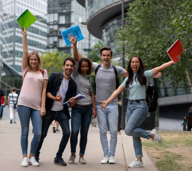 Excited group of students celebrating an accomplishment with arms up Excited group of students celebrating an accomplishment with arms up and looking at the camera smiling â education concepts exchange student stock pictures, royalty-free photos & images