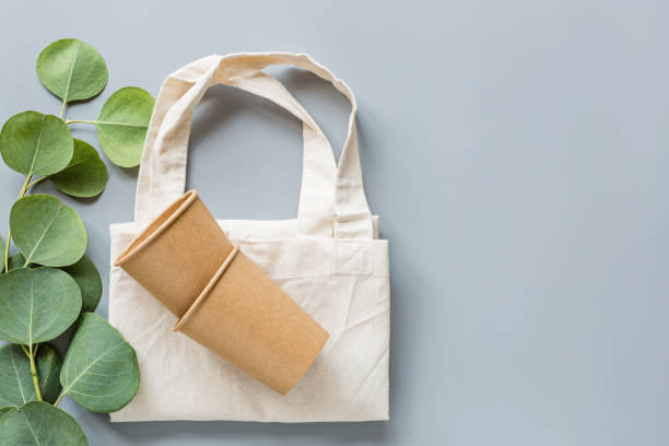 eco natural paper coffee cups and shopping bag flat lay on gray background. sustainable lifestyle concept. zero waste, plastic free items. stop plastic pollution. Top view, overhead, mock up, template tazas de café de papel natural ecológico y bolsa de compras plana sobre fondo gris. concepto de estilo de vida sostenible. cero residuos, artículos libres de plástico. detener la contaminación plástica. vista superior, sobrecarga, plantilla, mockup