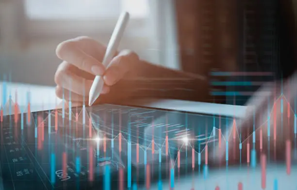 Photo of Stock exchange market concept, businessman trader looking on tablet with graphs analysis candle line in office room, diagrams on screen.