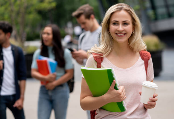 istock Beautiful female student drinking coffee outdoors 1185330942