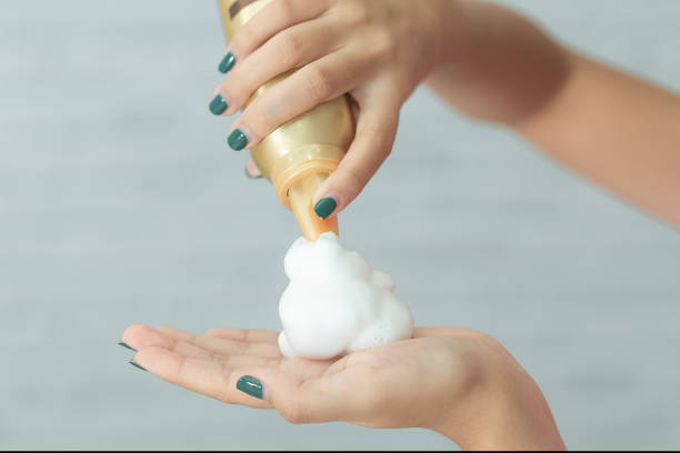 Close-up of hairdresser hairstylist hand with hair mousse spray. stock photo