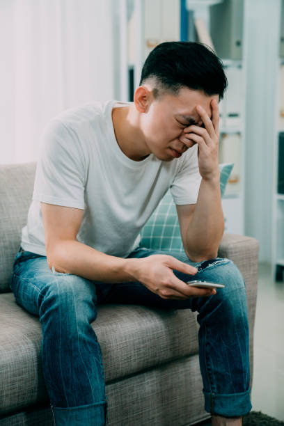 istock upset male holding cellphone at home 1185344249