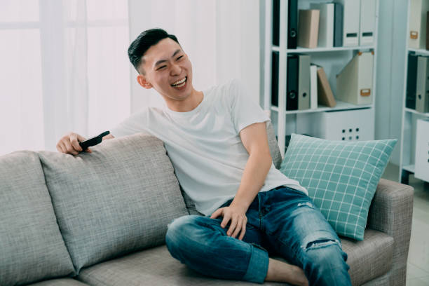 istock man watching television funny show laughing 1185344799