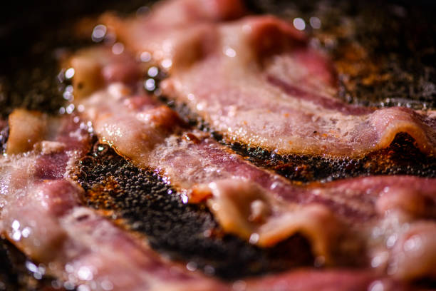 istock Bacon slice being cooked on a frying pan. Close up 1185347308
