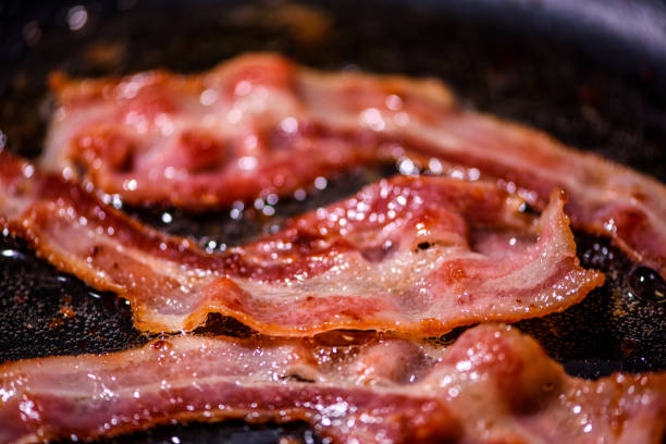 istock Bacon slice being cooked on a frying pan. Close up 1185347309