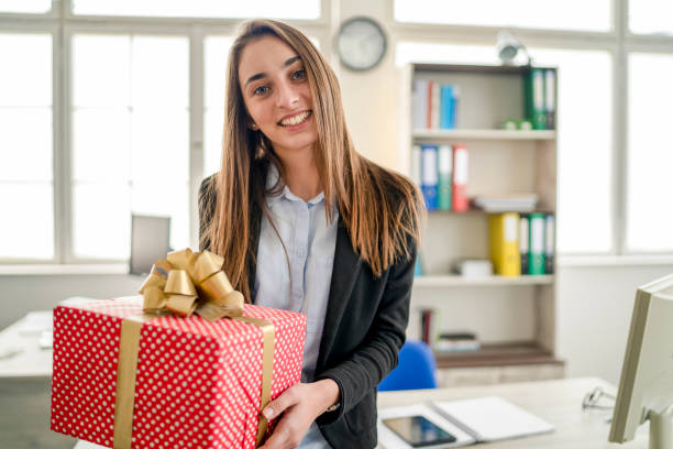 istock Beautiful young woman  with gift at the office 1185354467