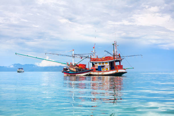 青い海、空、雲の風景の背景クローズアップ、ターコイズブルーの水に赤い木製漁船と美しい海景、タイの伝統的なアジアのオレンジ釣りトロール船 - cloud sailboat fishing boat fishing industry ストックフォトと画像