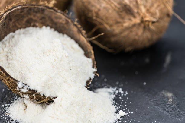 farina di cocco fresca su una lastra di ardesia (primo piano; messa a fuoco selettiva) - powdered coconut foto e immagini stock