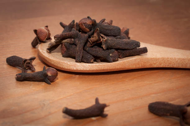 istock Cloves (syzygium aromaticum) on wooden spoon on a wooden table 1185363978
