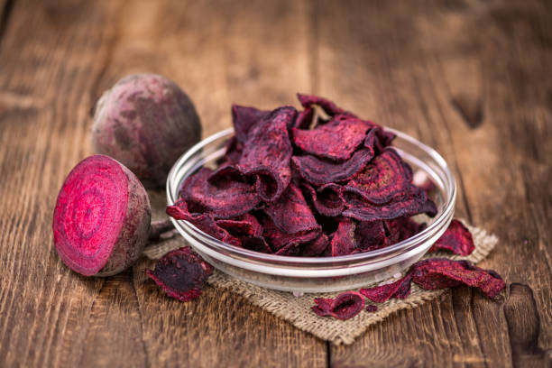 istock Some Beetroot Chips on a vintage wooden table (selective focus; close-up shot) 1185364171