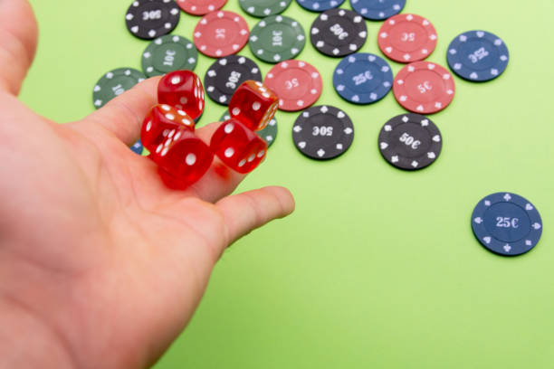 istock man throwing dice. Poker chips. Green background 1185364311