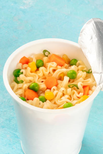 istock Ramen cup close-up, instant noodles in a plastic cup on a blue background 1185367836