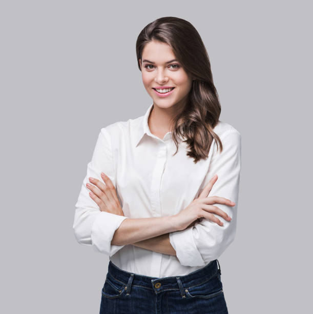 Smiling business woman portrait Beautiful girl with crossed arms looking at camera. Studio shot. Isolated on gray background woman arms folded stock pictures, royalty-free photos & images